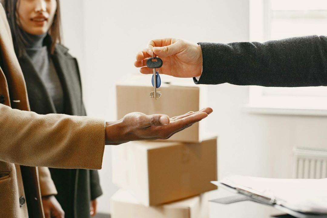 Foto de pessoas pegando a chave do apartamento, o locador e o lacatário