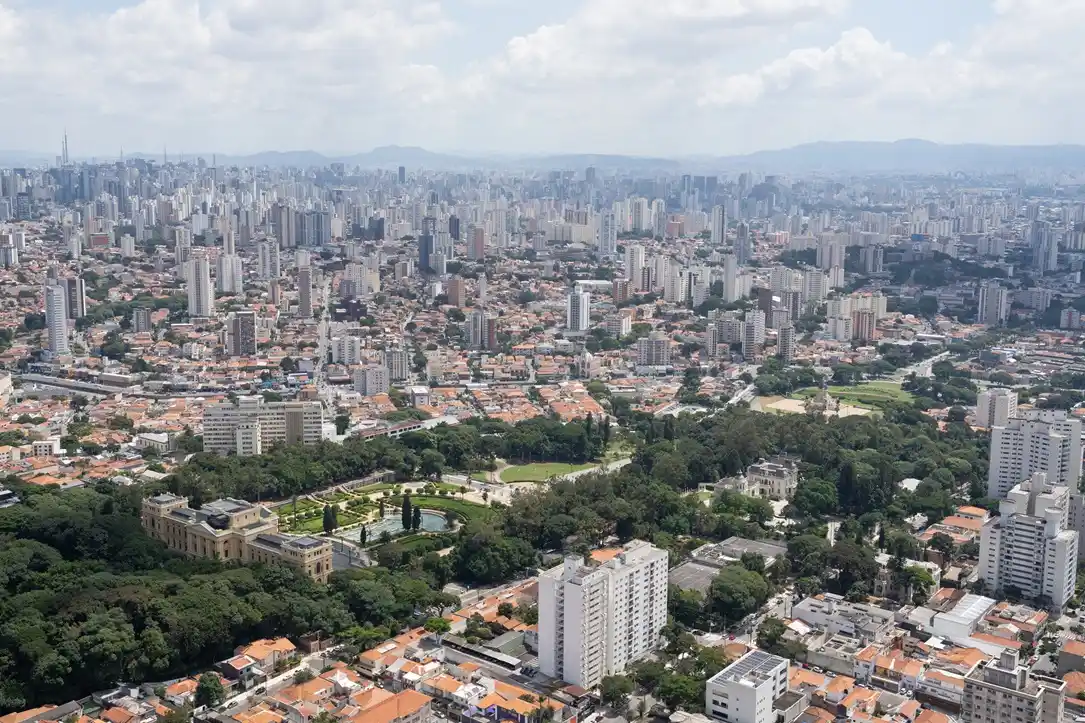 A imagem mostra uma vista aérea do bairro do Ipiranga, na cidade de São Paulo, com destaque para o Parque da Independência e o Museu do Ipiranga.