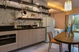 A imagem mostra o interior de um apartamento compacto com design moderno e elementos vintage.