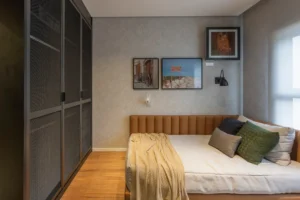 A imagem mostra o interior de um quarto moderno em um apartamento, que pode ser uma unidade à venda no empreendimento Vestra Cambuí.