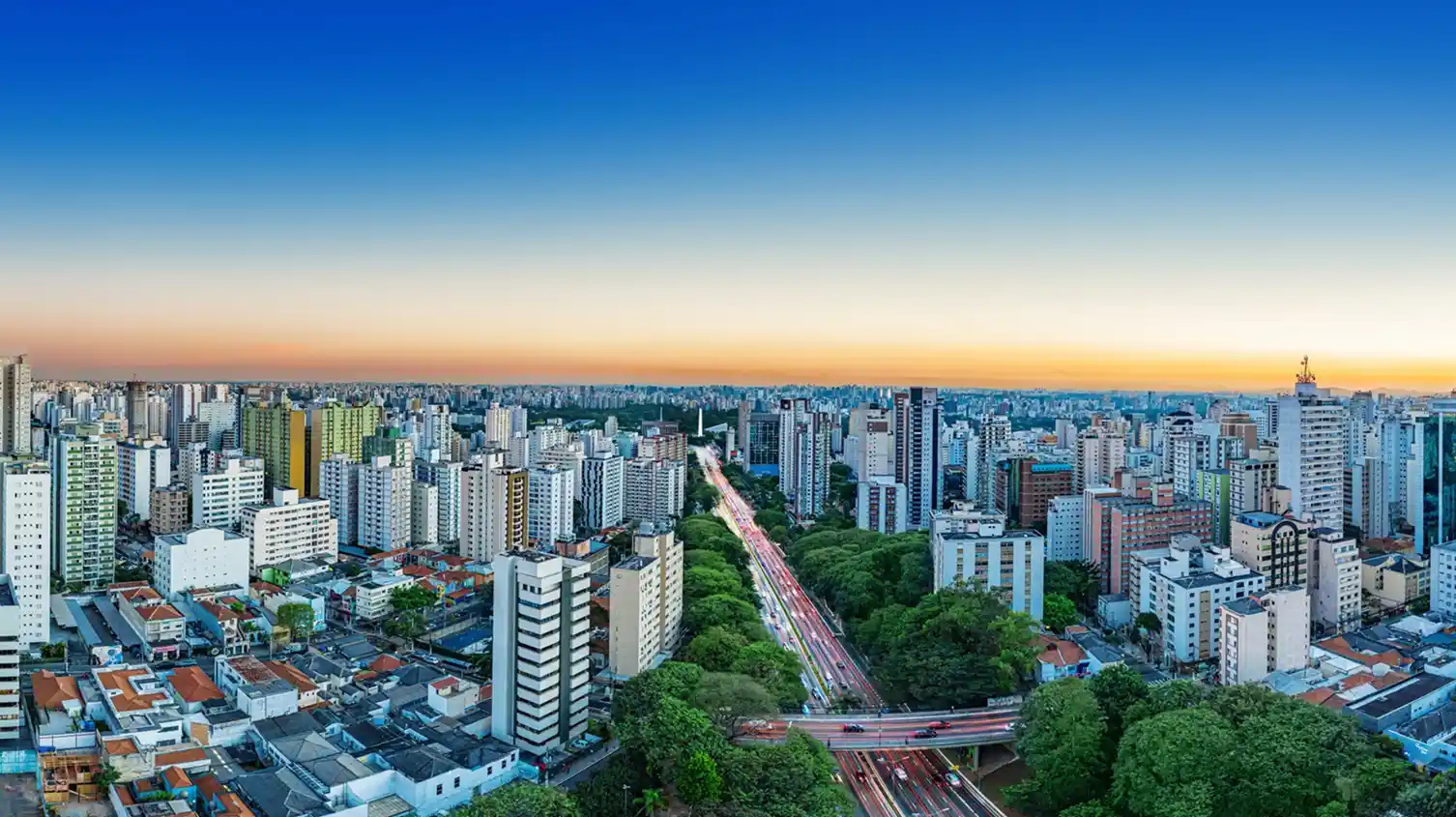 A imagem mostra uma vista aérea da cidade de São Paulo, Brasil, especificamente a área do bairro Paraíso, destacando a paisagem urbana densa e uma importante via expressa