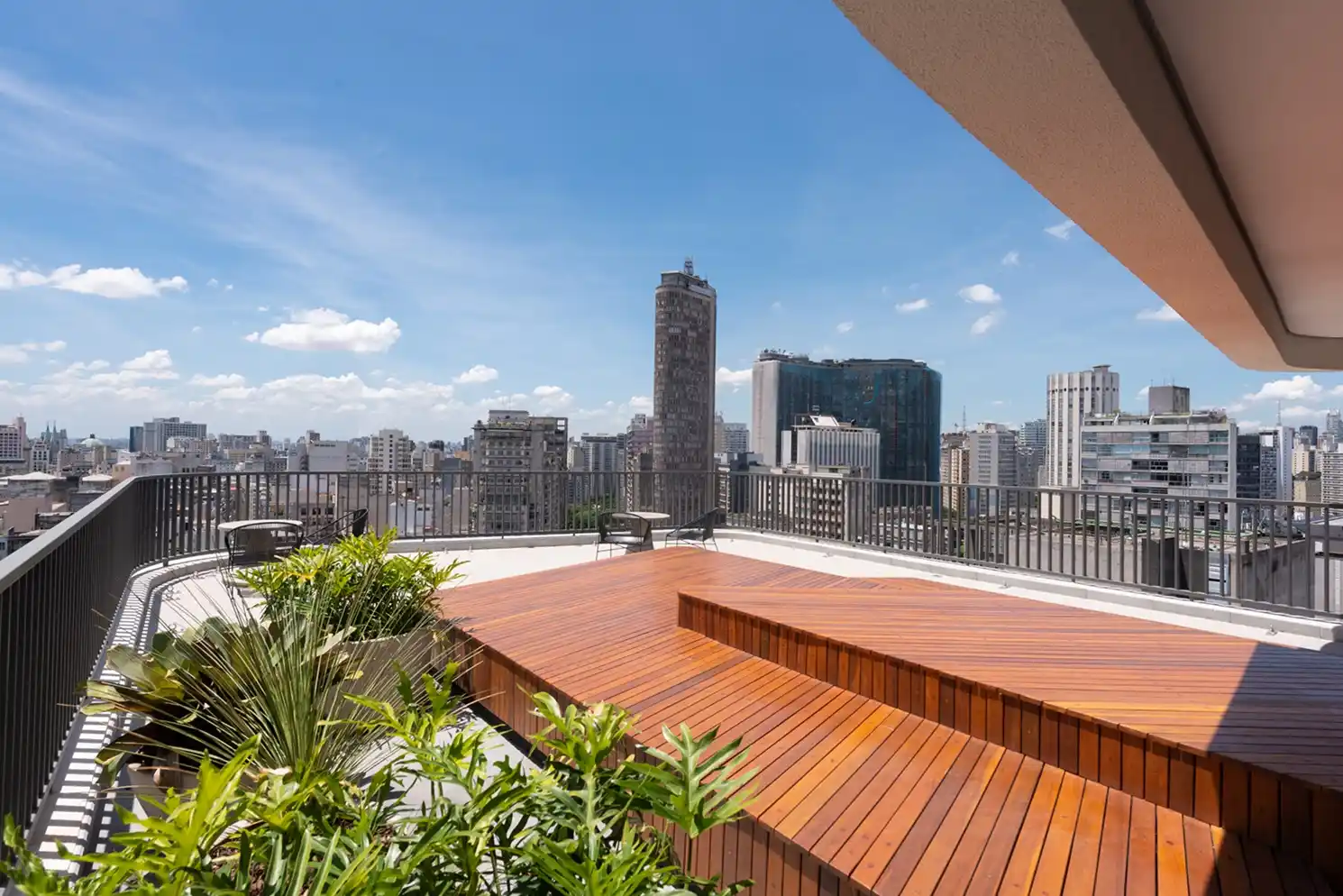 A imagem mostra o terraço com deck de madeira e vista panorâmica do empreendimento residencial Setin Downtown Nova República
