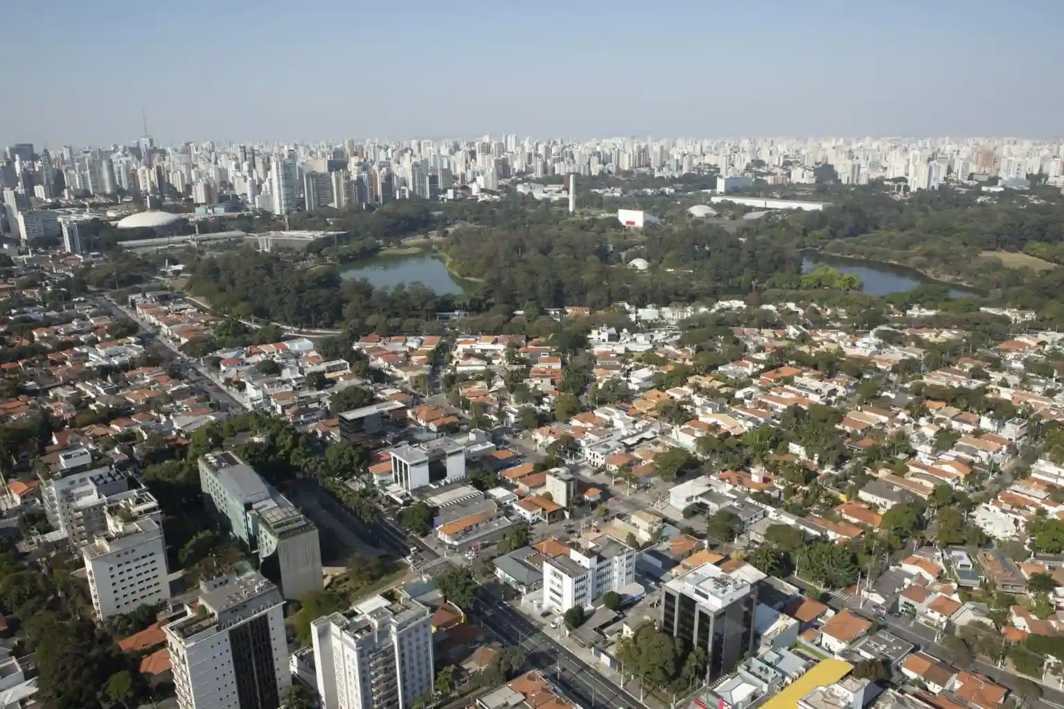 A imagem mostra uma vista aérea do bairro Jardim Paulista e do Parque Ibirapuera, em São Paulo.