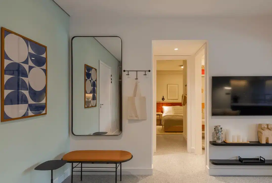 A imagem mostra um hall de entrada de um apartamento com decoração moderna e minimalista.