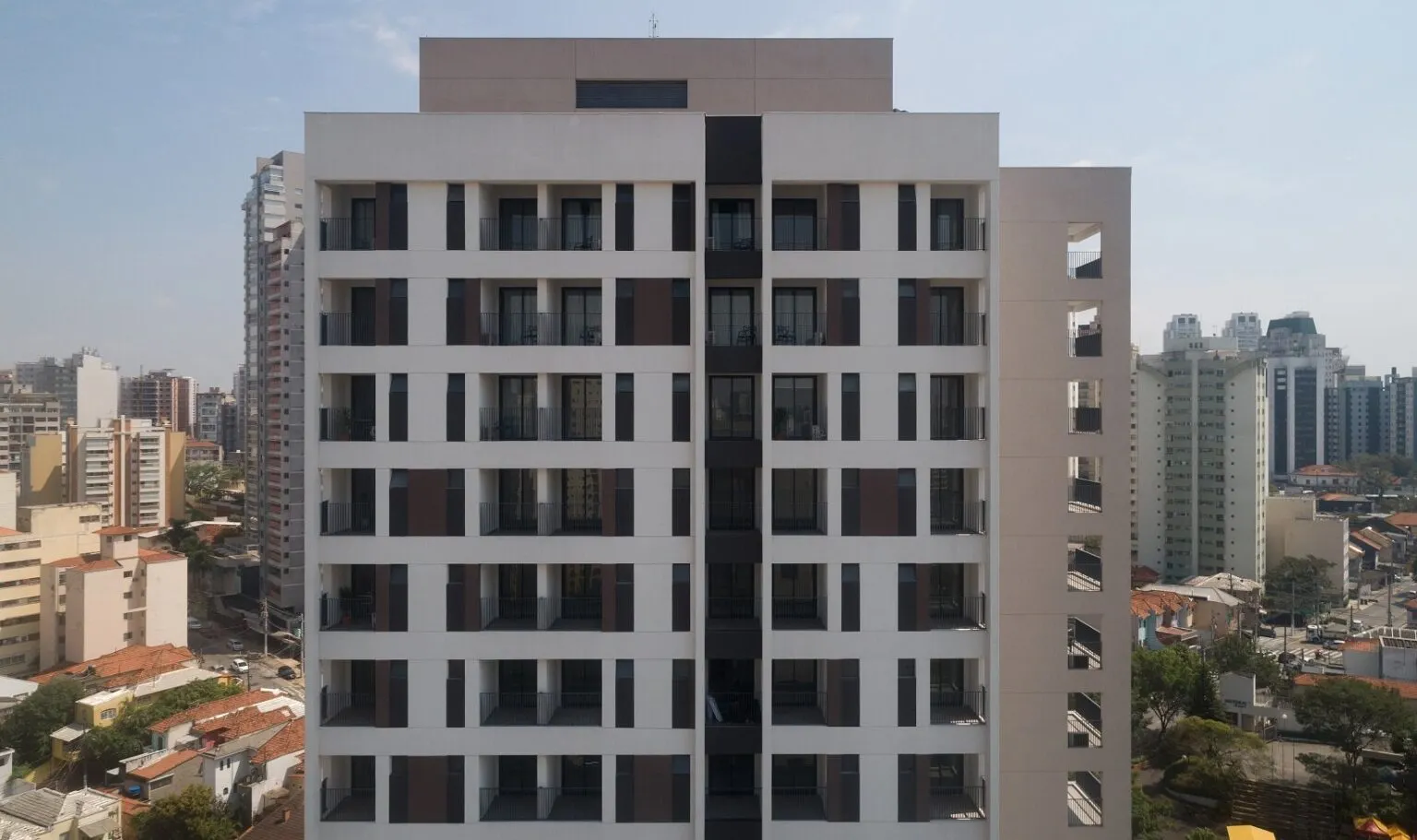 A imagem mostra um edifício residencial ou comercial moderno em uma área urbana densa.