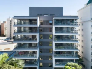 A imagem mostra um edifício residencial moderno com uma fachada marcante e varandas espaçosas.