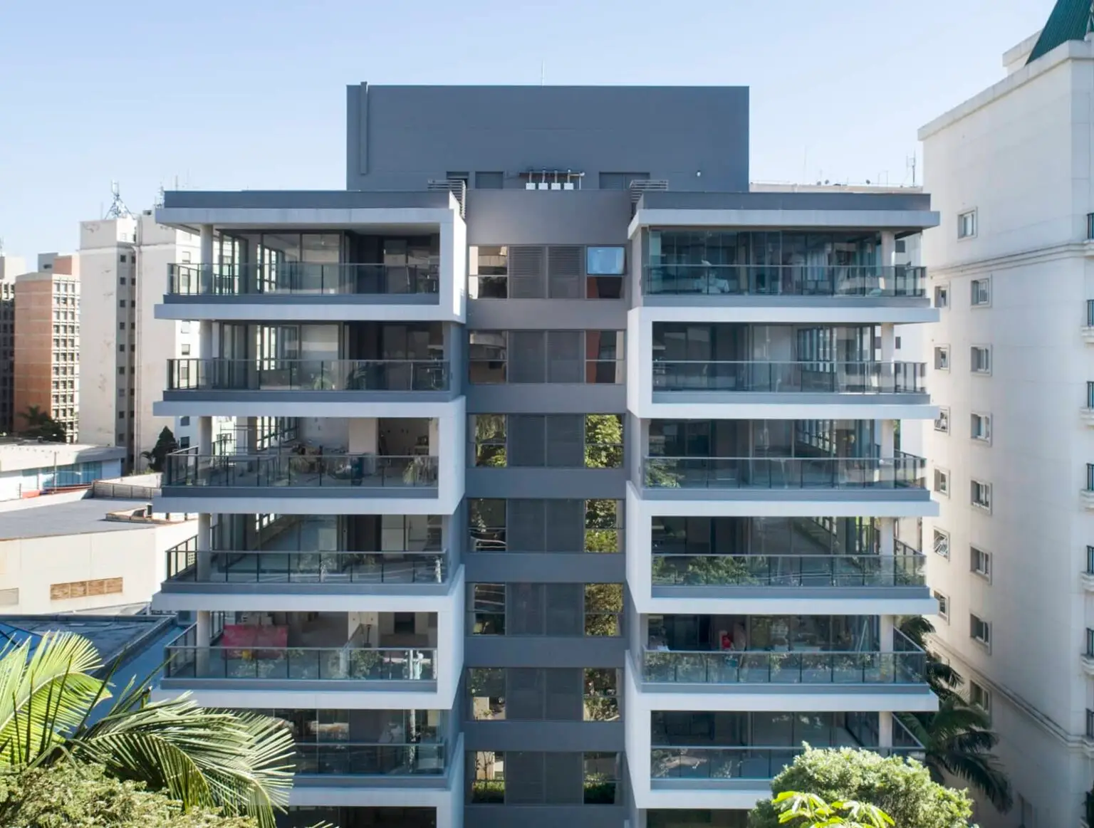 A imagem mostra um edifício residencial moderno com uma fachada marcante e varandas espaçosas.