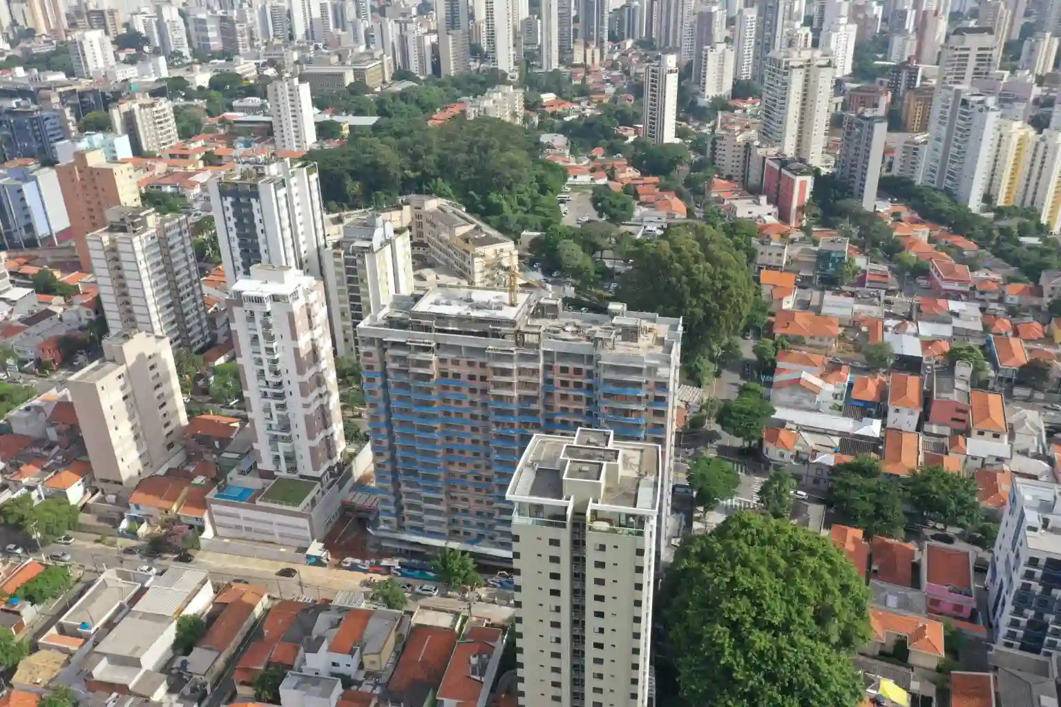 A imagem mostra uma vista aérea da Vila Clementino, em São Paulo, Brasil, focando em um edifício residencial em construção.