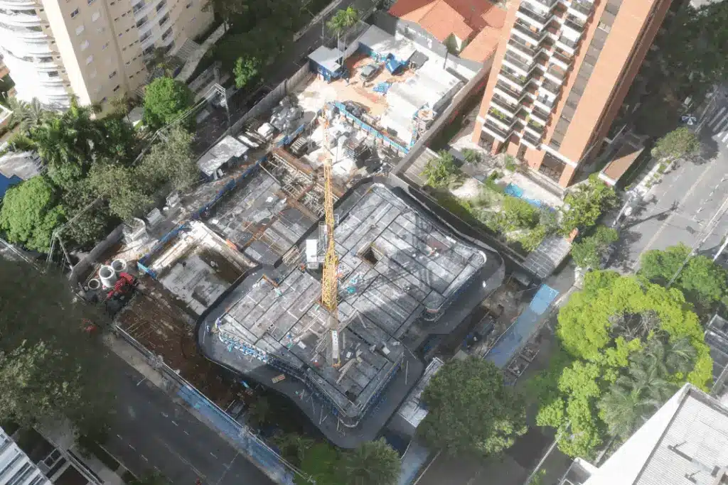 A imagem mostra uma vista aérea de um canteiro de obras em uma área urbana, provavelmente em São Paulo - SP.